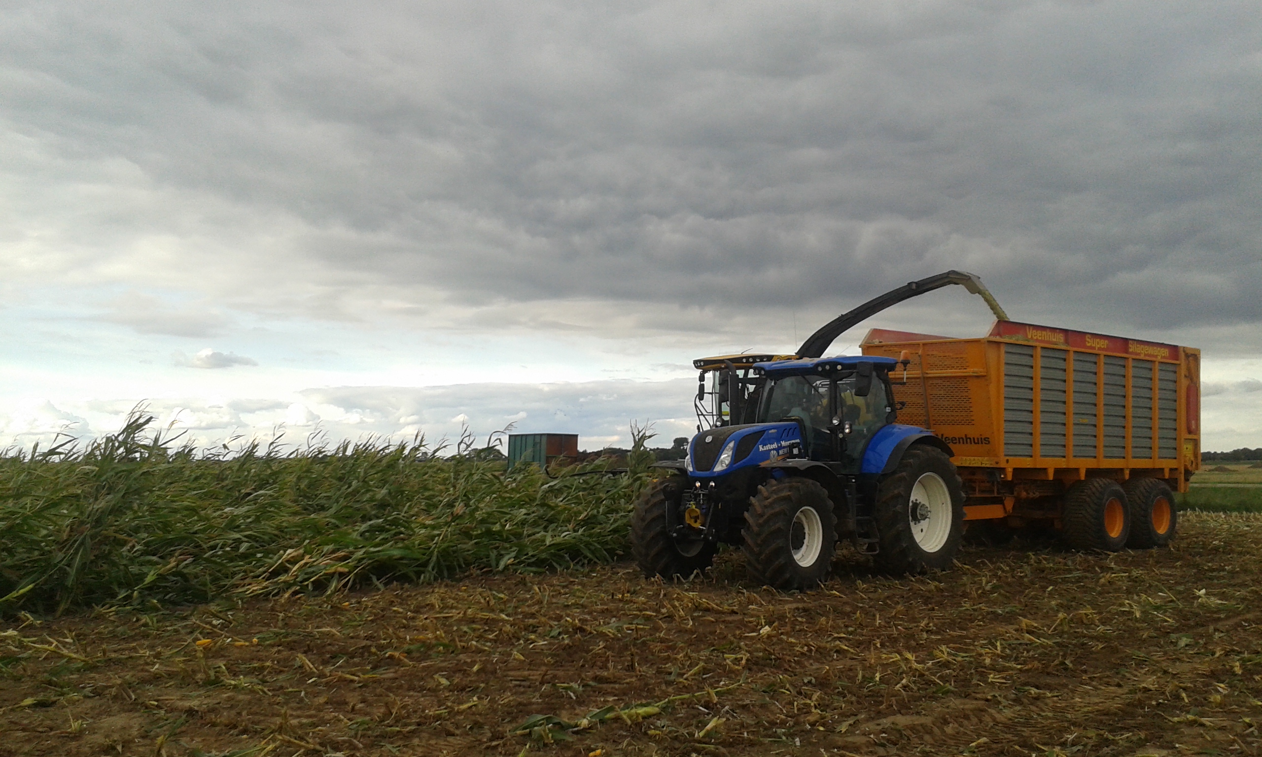 Boer aan het werk op het veld van de Lange Hoeve tijdens uitdagende weersomstandigheden.